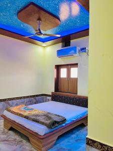 a bedroom with a bed with a ceiling fan at Hotel Jiwan Palace Phalodi in Phalodi