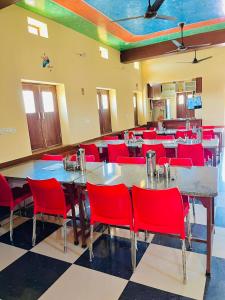 a dining room with red chairs and a large table at Hotel Jiwan Palace Phalodi in Phalodi
