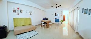 ein Wohnzimmer mit einem Tisch und einem Stuhl in der Unterkunft Transit Nest 1BHK in Guwahati