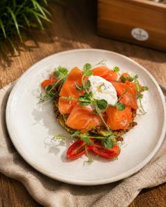 a plate of food with tomatoes and sour cream at Royal Rooms Self Check-in in Poznań