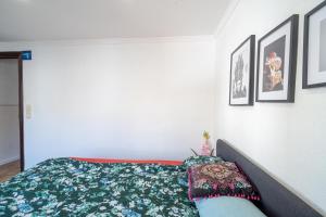 a bedroom with a bed and some pictures on the wall at Casa Aposento in Alaquas +2 photos