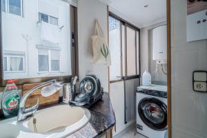 a bathroom with a sink and a washing machine at Casa Aposento in Alaquas