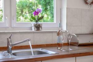 a kitchen counter with a sink and two wine glasses at Ferienwohnung Annabelle in Bodman-Ludwigshafen +30 photos