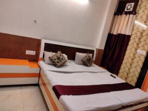 a bed with two pillows on it in a room at Shraddha Hotel in Alīgarh