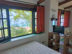 a bedroom with a bed and a large window at Appartamenti Salato in Tropea