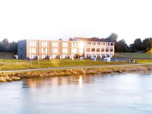 a building next to a body of water at BE BIO Hotel be natural - direkt am Wasser in Tönning