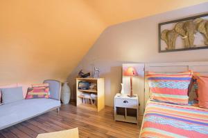 a bedroom with a bed and a couch at Le Lys De Mer - Chambre in Dragey