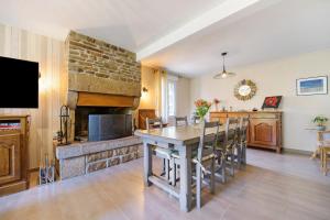 a kitchen with a table and a fireplace at Le Lys De Mer - Chambre in Dragey