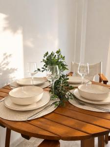 a wooden table with plates and wine glasses on it at KallitheaDeluxe in Kallithea Halkidikis