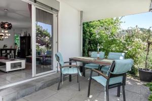 a patio with a wooden table and chairs on a patio at Ferienwohnung Annabelle in Bodman-Ludwigshafen