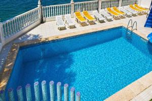 a swimming pool with lounge chairs and a swimming pool at Hotel Bossh Lido in Benidorm