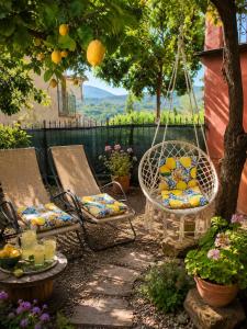 a patio with two chairs and a table and a swing at Limonaia in Villa Viani