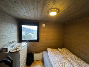 a small room with a bed and a window at Hyggeli in Vadsø