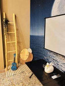a room with a screen and a table with a guitar at Here after us homestay in Dahu +28 photos