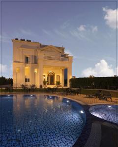 a house with a swimming pool in front of a building at Rajwada Hotel and Resort in Bareilly