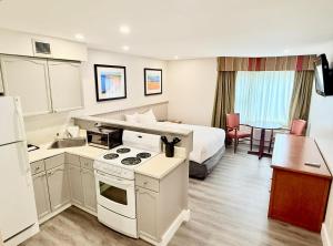 a hotel room with a bed and a kitchen at Charlottetown Inn & Conference Centre in Charlottetown