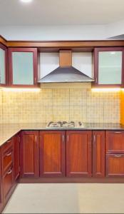 a kitchen with wooden cabinets and a stove at Luxe Kochi Flat Backwater Views in Cochin +4 photos