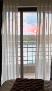 a bedroom with a window with a view of the ocean at Luxe Kochi Flat Backwater Views in Cochin