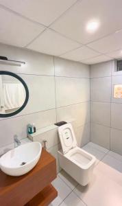 a white bathroom with a sink and a toilet at Luxe Kochi Flat Backwater Views in Cochin