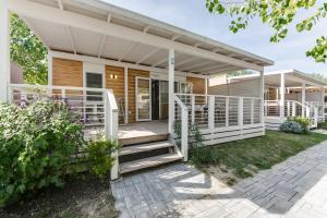 a home with a porch and stairs to a house at Camping Adria Riccione in Riccione +9 photos