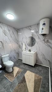 a bathroom with a white toilet and a sink at Guest House Alim in Karakol