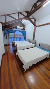 two beds in a room with wooden floors at Feelgood dive resort in Basbas