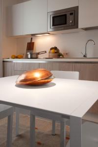 uma tigela de madeira numa mesa branca numa cozinha em Residenza Dante em Nuoro
