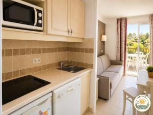 a kitchen with a sink and a microwave at Magiuli Village du Rouret in Grospierres