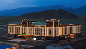 a rendering of a hotel building with mountains in the background at Holiday Inn Bayanbulak by IHG in Bayanbulak