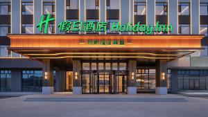 a building with a sign on the front of it at Holiday Inn Bayanbulak by IHG in Bayanbulak