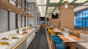 a restaurant with tables and chairs and food on display at Holiday Inn Bayanbulak by IHG in Bayanbulak +101 photos