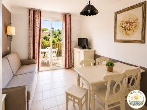 a living room with a couch and a table at Magiuli Village du Rouret in Grospierres