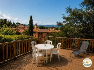 a white table and chairs on a wooden deck at Magiuli Village du Rouret in Grospierres
