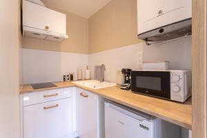 a kitchen with a counter top with a microwave at Suite de La Dune - Studio - Hypercentre in Narbonne