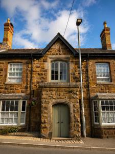 an old brick house with a door and a street light at The Arundell in Lifton