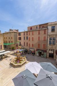 a group of umbrellas in a courtyard with buildings at Suite de La Dune - Studio - Hypercentre in Narbonne