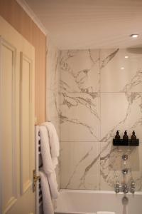 a bathroom with a shower with a marble wall at The Arundell in Lifton +70 photos
