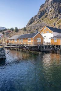 ein Gebäude auf einem Dock neben einem Gewässer in der Unterkunft Åsebua - Renovated rorbu with seaview in Sørvågen