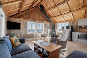 ein Wohnzimmer mit Sofa und Tisch in der Unterkunft Åsebua - Renovated rorbu with seaview in Sørvågen
