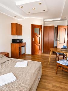 a room with a bed and a table and a kitchen at Belona in Stegna