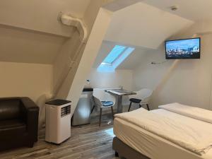 a bedroom with a bed and a desk and a tv at Eifelerhof hotel Monschau in Monschau