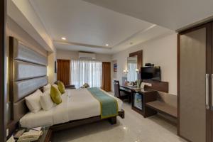 a bedroom with a bed and a desk and a television at Hotel Suba Galaxy Mumbai in Mumbai