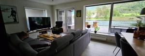 a man laying on a couch in a living room at Modern lakefront apt with view - EV plug in Stryn +26 photos