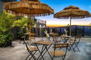 a patio with tables and chairs and umbrellas at Cesia Boutique - ססיה סוויטות בוטיק in Biriyya