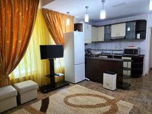 a kitchen with a refrigerator and a couch and a table at Vila Smarald Apartments in Neptun