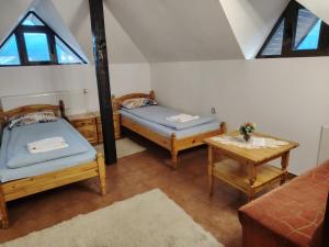 a attic room with two beds and a table at Къща за гости Бащин дом in Apriltsi +143 photos