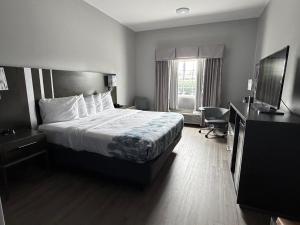 a hotel room with a bed and a television at Guesthouse Inn & Suites Lexington in Lexington