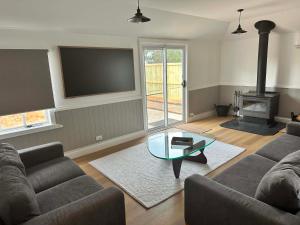 a living room with a couch and a table and a tv at Tranquillity by the sea in Killarney