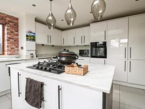a kitchen with white cabinets and a pot on the stove at 57 Howden Avenue in Doncaster +9 photos