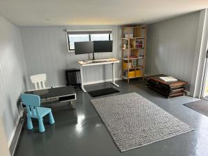 a living room with a desk and a blue chair at Tranquillity by the sea in Killarney